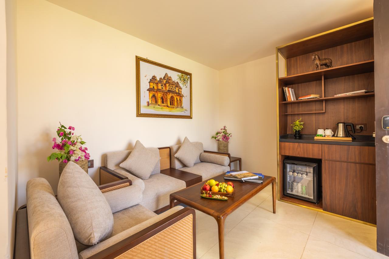 Suite living room with lounge seating and mini bar at Vijayshree Resort, Hampi